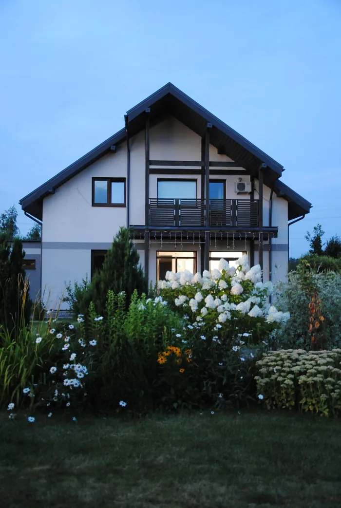 Modernes Einfamilienhaus mit üppigem Garten im Abendlicht